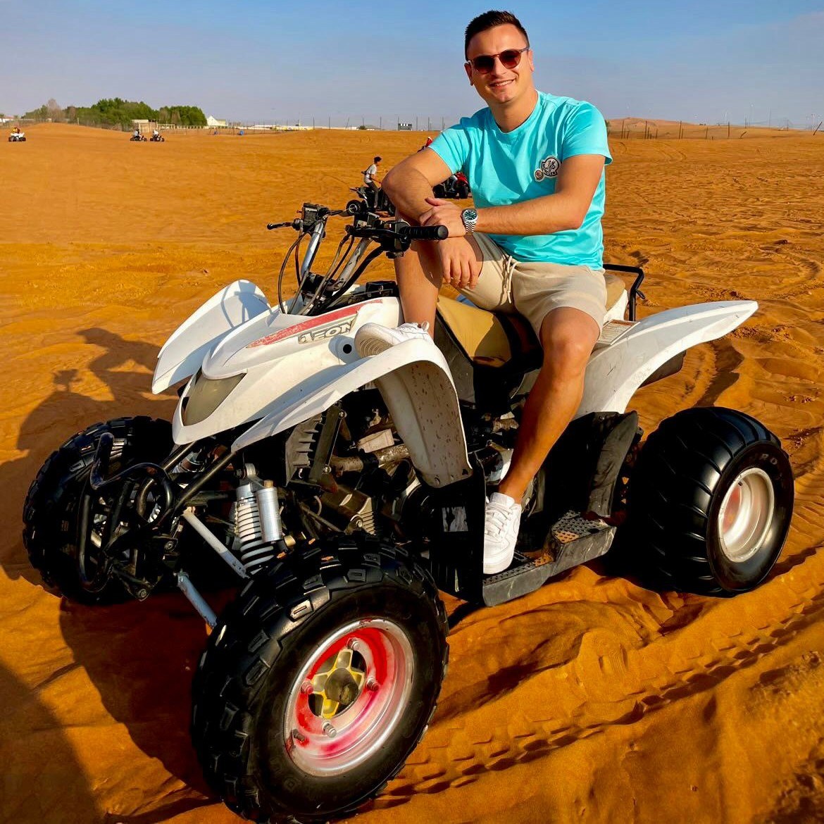 Guest posing with a quad bike during a desert safari activity break